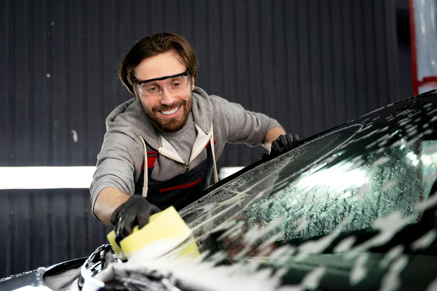 title article with man cleaning cars in the background